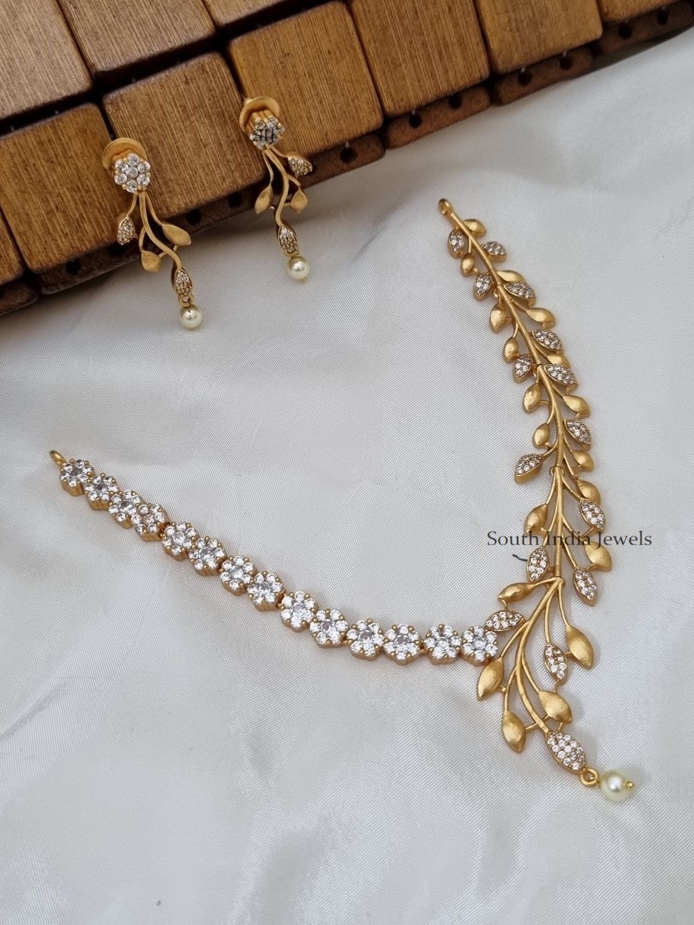 gold necklace with white stone designs